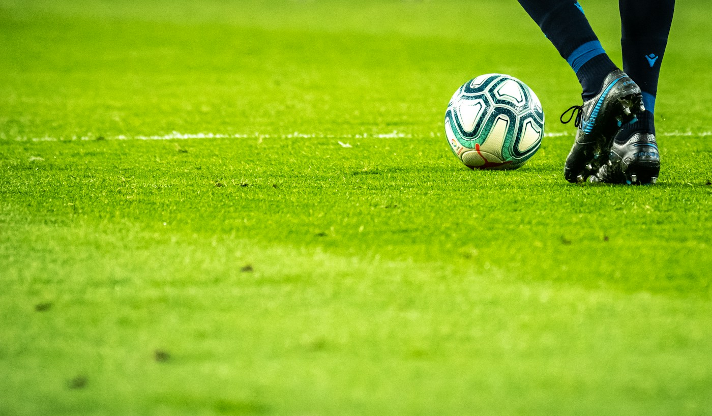 Cancha y balón de fútbol al atardecer